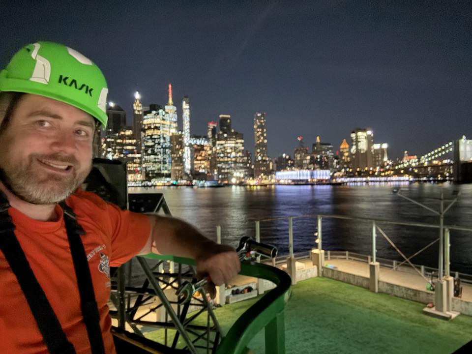 Sean Saphire rigging at a waterfront venue with the Manhattan skyline at night